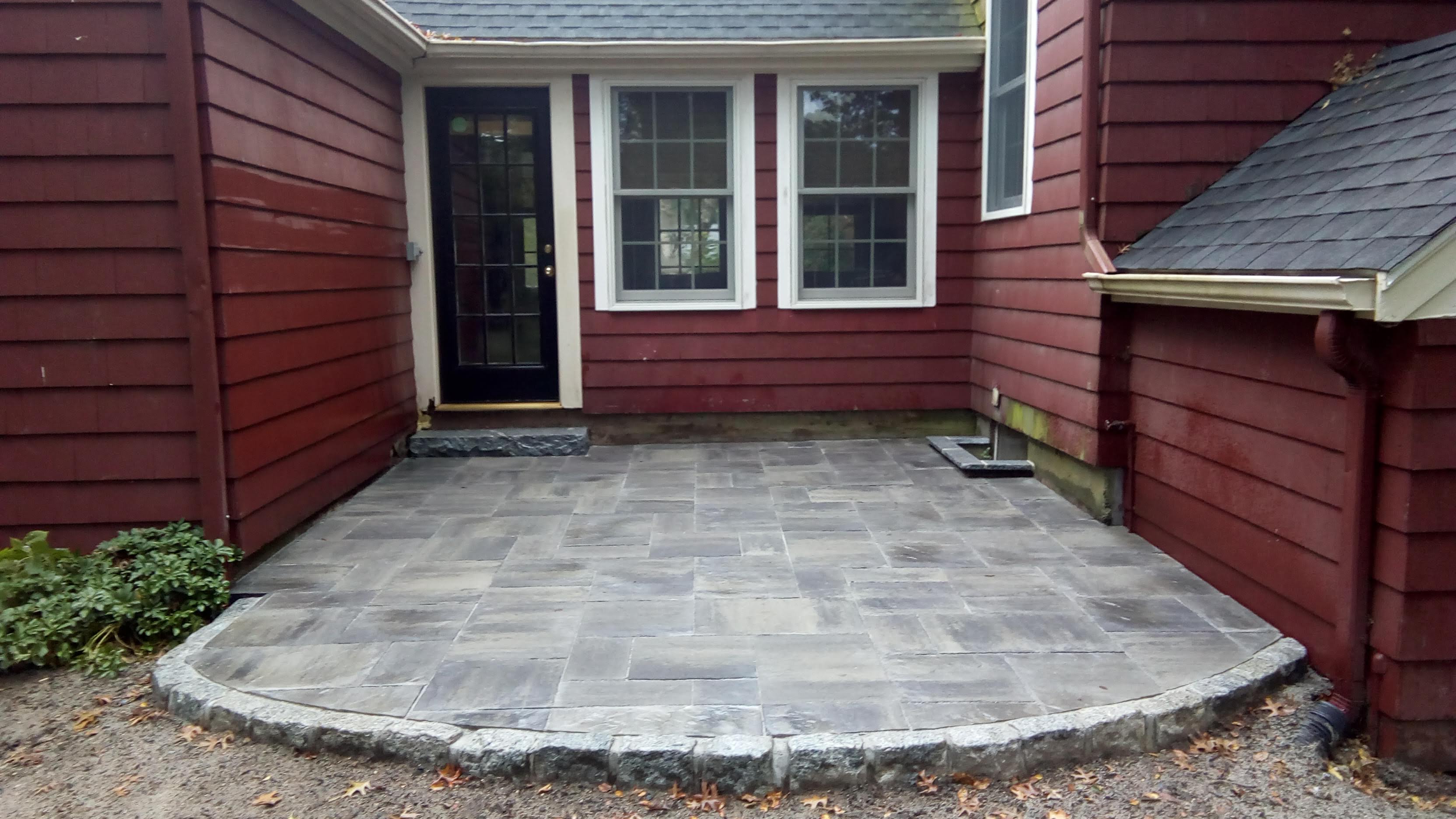 Backyard paver patio with cobblestone border and granite step in Bridgewater, MA — Mass Patio & Masonry